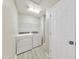 Bright laundry room features a washer, dryer, wire rack shelving, and stylish gray wood-look flooring at 3816 Harris Nw Blvd, Kennesaw, GA 30144