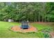 Fenced backyard has a play area with trampoline and fire pit, lots of trees at 4274 Timber Trace Road, Loganville, GA 30052