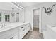 Bright bathroom with a double sink vanity, tub, and funny decal at 4274 Timber Trace Road, Loganville, GA 30052