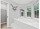 Corner soaking tub in Primary bathroom with natural light and funny decal at 4274 Timber Trace Road, Loganville, GA 30052