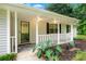 Welcoming front porch with white railing, complemented by lush greenery at 4274 Timber Trace Road, Loganville, GA 30052