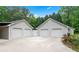 Two, two-car garages with a private white fence dividing the garages and colorful flower beds at 4274 Timber Trace Road, Loganville, GA 30052