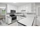 Well-lit kitchen with stainless steel appliances, white cabinets, and neutral backsplash at 4274 Timber Trace Road, Loganville, GA 30052