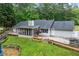 Rear exterior of home showcasing its screened in porch, deck, patio, and landscaping at 4274 Timber Trace Road, Loganville, GA 30052