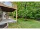 Spacious backyard featuring a covered patio, mature trees, and lush green lawn at 1897 Alcovy Trace Way Way, Lawrenceville, GA 30045