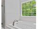 Modern bath with tub and shower boasts natural light through a large picture window at 1897 Alcovy Trace Way Way, Lawrenceville, GA 30045