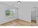 This bedroom features a window, natural light, hardwood flooring, and a glimpse into the closet at 1897 Alcovy Trace Way Way, Lawrenceville, GA 30045