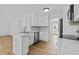 Bright kitchen features white cabinets, stainless steel appliances, and hardwood flooring at 1897 Alcovy Trace Way Way, Lawrenceville, GA 30045