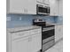Close up of the kitchen featuring stainless steel appliances, granite counters, and stylish blue backsplash at 1897 Alcovy Trace Way Way, Lawrenceville, GA 30045