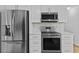 Modern kitchen with stainless steel appliances, white cabinets, and tiled backsplash at 1897 Alcovy Trace Way Way, Lawrenceville, GA 30045