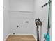 A simple laundry room features wood-look flooring, white walls, and storage shelf for household organization at 1897 Alcovy Trace Way Way, Lawrenceville, GA 30045