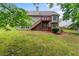 Expansive backyard with a multi-level wooden deck, lush green lawn, mature trees, and a partial view of the neighborhood at 2701 Windsor Nw Ct, Kennesaw, GA 30144