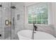 Luxurious bathroom with freestanding tub, glass shower, marble accents, and natural light at 2701 Windsor Nw Ct, Kennesaw, GA 30144