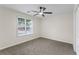 Cozy bedroom features carpeted flooring, a ceiling fan, and a large window for natural light at 2701 Windsor Nw Ct, Kennesaw, GA 30144