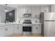 Well-lit kitchen with stainless steel appliances, light gray cabinets, and view into the living area at 2701 Windsor Nw Ct, Kennesaw, GA 30144