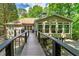 Backyard view with a deck overlooking wooded scenery, and a ramp to the house at 2825 Lake Ct, Cumming, GA 30041