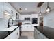 Bright kitchen featuring white cabinets, black countertops and backsplash, and stainless appliances at 2825 Lake Ct, Cumming, GA 30041