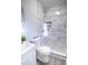 Modern bathroom featuring a stand-up shower with stylish marble-look tile surround and gray mosaic floor at 3893 Bonnie Se Ln, Atlanta, GA 30354