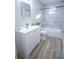 Updated bathroom with white cabinets, a bathtub, marble tiling, and light wood flooring at 3893 Bonnie Se Ln, Atlanta, GA 30354