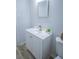 Charming bathroom featuring white cabinets, light wood flooring, and a large mirror at 3893 Bonnie Se Ln, Atlanta, GA 30354