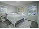 Cozy bedroom featuring a comfortable bed, stylish nightstand, modern art, and plenty of natural light from two windows at 3893 Bonnie Se Ln, Atlanta, GA 30354