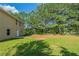 Large backyard with green grass, mature trees, and the back of the house with a patio at 7250 Old Chapel, Atlanta, GA 30349