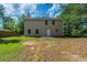 Large backyard with green grass, mature trees, and the back of the house with a patio at 7250 Old Chapel, Atlanta, GA 30349