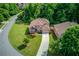 Aerial shot of a brick home featuring lush greenery, a long driveway, and manicured landscaping at 764 Morganton Dr, Johns Creek, GA 30024