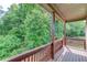 Covered porch with railing overlooks lush greenery, offering a peaceful outdoor retreat at 764 Morganton Dr, Johns Creek, GA 30024