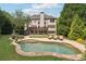 Expansive backyard with inground pool, lush landscaping, and an outdoor seating area at 100 Pine Mist Cir, Alpharetta, GA 30022