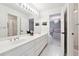 Bright bathroom featuring double sinks, white tile flooring, and a view into the bedroom at 100 Pine Mist Cir, Alpharetta, GA 30022