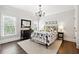 Charming bedroom with hardwood floors, a decorative chandelier, and windows providing natural light at 100 Pine Mist Cir, Alpharetta, GA 30022