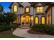 Covered front entry featuring keystone accents, curved windows, and manicured landscaping at 100 Pine Mist Cir, Alpharetta, GA 30022