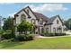 Elegant two-story home with a well-manicured lawn and lush landscaping at 100 Pine Mist Cir, Alpharetta, GA 30022