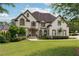 Beautiful two-story home with lush green lawn and meticulously manicured landscaping at 100 Pine Mist Cir, Alpharetta, GA 30022