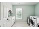 Bright laundry room featuring window, utility sink, and modern washing machine at 100 Pine Mist Cir, Alpharetta, GA 30022