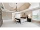 This bright main bedroom includes a tray ceiling, a neutral palette, and large windows for ample natural light at 100 Pine Mist Cir, Alpharetta, GA 30022
