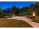 The swimming pool area features a stone pool wall, professional landscaping, and heat lamps at 100 Pine Mist Cir, Alpharetta, GA 30022