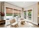 Sun-drenched sun room with large windows, comfortable seating, and a view of the backyard at 100 Pine Mist Cir, Alpharetta, GA 30022