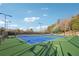 Wide shot of the community tennis courts with new light fixtures and green turf at 100 Pine Mist Cir, Alpharetta, GA 30022