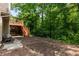 View of a backyard with a two-story deck, patio furniture, landscaping beds, and lush greenery at 1019 Legacy Walk, Woodstock, GA 30189