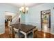 Elegant dining room boasting wainscoting, hardwood floors, stylish chandelier, and a glimpse into a modern kitchen at 1019 Legacy Walk, Woodstock, GA 30189