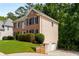 Well-maintained home with a side garage, lush lawn, and surrounded by mature trees, offering both convenience and natural beauty at 1019 Legacy Walk, Woodstock, GA 30189