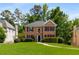Beautiful brick home with a well-maintained lawn, mature trees, and classic architectural details, offering timeless curb appeal at 1019 Legacy Walk, Woodstock, GA 30189