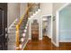 Welcoming foyer featuring hardwood floors, a staircase with wooden railing, and an inviting view into the adjacent living spaces at 1019 Legacy Walk, Woodstock, GA 30189