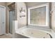 Bright main bathroom with a jacuzzi tub and a separate glass-enclosed shower at 1019 Legacy Walk, Woodstock, GA 30189