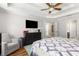 Spacious main bedroom featuring a ceiling fan, natural light, wood floors, and a comfortable seating area at 1019 Legacy Walk, Woodstock, GA 30189