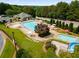 Community pool and waterslide surrounded by lush green space and mature trees in a neighborhood setting at 1019 Legacy Walk, Woodstock, GA 30189