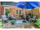 Charming patio area with brick flooring, seating, and a blue umbrella at 2505 Northlake Court Northeast, Atlanta, GA 30345