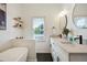 Bathroom with double vanity sinks, quartz countertops, a free-standing tub, and a window for natural light at 683 Terry Se St, Atlanta, GA 30315